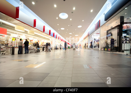 Große Halle und Kunden im Handelszentrum mit Geschäften auf beiden Seiten Stockfoto