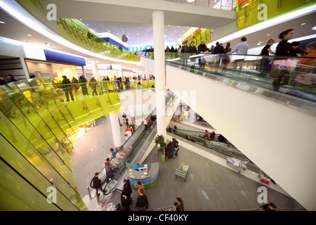 Blick von der Rolltreppe auf Geschäfte und Masse der Käufer im Einkaufszentrum Stockfoto