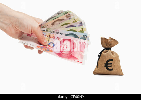 Viele verschiedene chinesische Yuan Rechnungen sind in der Hand gehalten. In der Nähe ist ein Geldbeutel mit Euro-Währung, weißen Hintergrund. Stockfoto