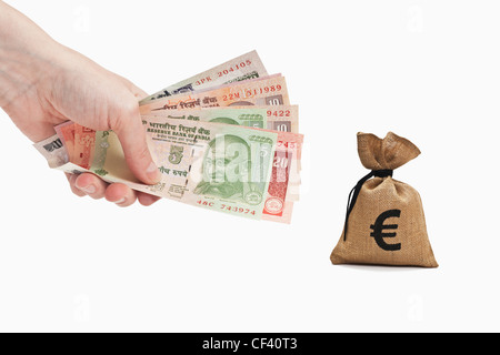 Viele verschiedene indische Rupie Rechnungen sind in der Hand gehalten. In der Nähe ist ein Geldbeutel mit einer Euro-Währung-Zeichen. Hintergrund weiß. Stockfoto