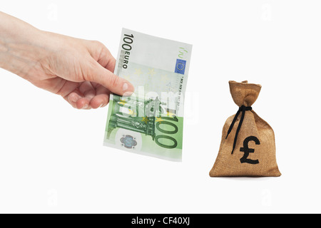 Ein 100 Euro-Schein ist in der Hand gehalten. In der Nähe ist ein Geldbeutel mit einem Nummernzeichen Währung. Stockfoto