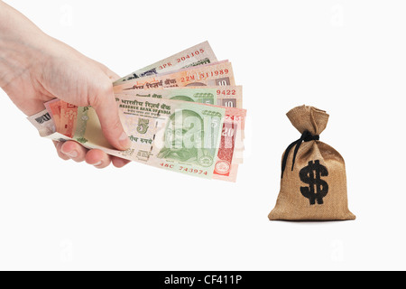 Viele verschiedene indische Rupie Rechnungen sind in der Hand gehalten. In der Nähe ist ein Geldbeutel mit einem US-Dollar-Währung-Zeichen. Stockfoto