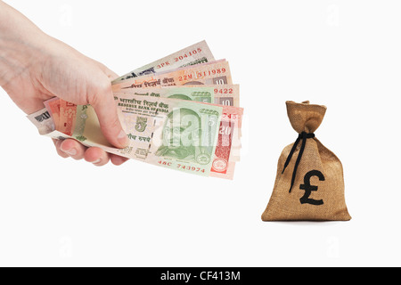 Viele verschiedene indische Rupie Rechnungen sind in der Hand gehalten. In der Nähe ist ein Geldbeutel mit ein Nummernzeichen Währung, weißen Hintergrund. Stockfoto