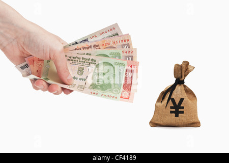 Viele verschiedene indische Rupie Rechnungen sind in der Hand gehalten. In der Nähe ist ein Geldbeutel mit einem japanischen Yen Währungszeichen. Stockfoto