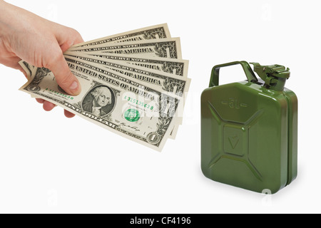 Fünf 1 US-Dollar Rechnungen werden in der Hand, in der Nähe von gehalten ist eine grüne 5 Liter Benzin Kanister Metall, Hintergrund weiß. Stockfoto