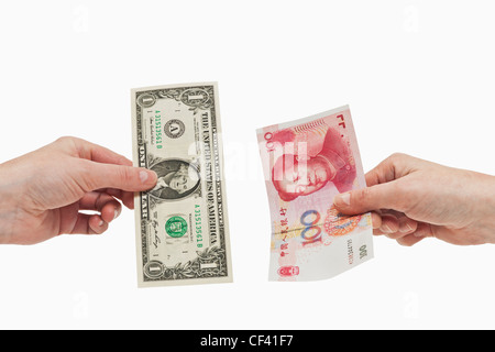 Ein 1 US-Dollar-Schein in der Hand gehalten wird. Auf der anderen Seite eine 100 Yuan Rechnung in der Hand, weißen Hintergrund gehalten. Stockfoto