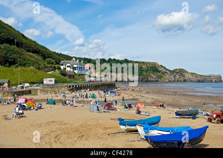 Menschen genießen die Sommersonne auf Whitbys Strand in der Nähe von Whitby. Stockfoto