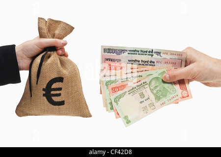 Viele verschiedene indische Rupie Rechnungen sind in der Hand gehalten. Auf der anderen Seite ein Geldsack mit Euro-Währung-Zeichen ist. Stockfoto