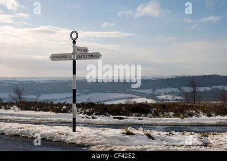 Schnee umgibt einen Wegweiser an einer Straße auf die North York Moors. Stockfoto