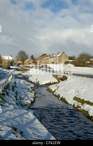 Schnee bedeckt den Boden neben einem Fluss durchquert Hutton-le-Hole Dorf. Stockfoto