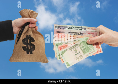 Viele verschiedene indische Rupie Rechnungen sind in der Hand gehalten. Auf der anderen Seite ist ein Geldbeutel mit US-Dollar-Währung-Zeichen. Stockfoto