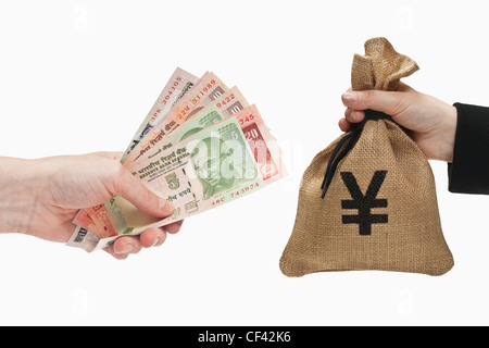 Viele verschiedene indische Rupie Rechnungen sind in der Hand gehalten. Auf der anderen Seite ein Geldbeutel mit japanischen Yen Währungszeichen. Stockfoto