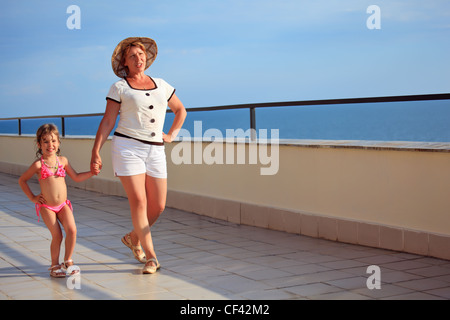 ältere Frau und kleine Mädchen gehen auf die Veranda in der Nähe von Küste Stockfoto