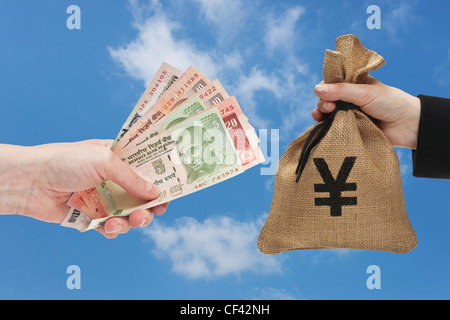 Viele verschiedene indische Rupie Rechnungen sind in der Hand gehalten. Auf der anderen Seite ein Geldbeutel mit japanischen Yen Währungszeichen. Stockfoto