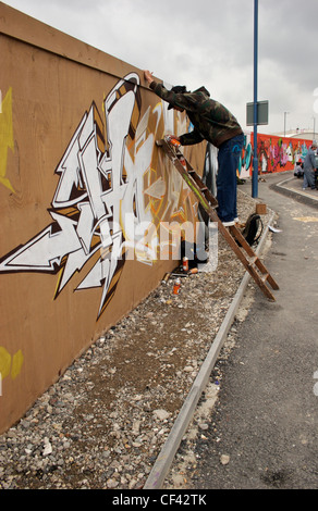 Graffiti-Künstler auf Anlegeleiter. Das Wort "Graffiti" ist der Plural von "Graffito" und stammt aus dem italienischen Wort "Graffia Stockfoto