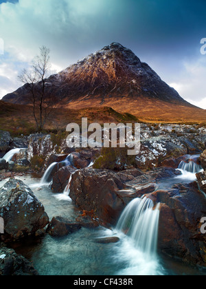 Wasser fließt über die Felsen in Glen Etive flussabwärts von Buachaille Etive Mor, eine fast perfekte pyramidale Form Berg an der er Stockfoto