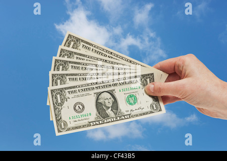 Fünf 1 ist US-Dollar Rechnungen in der Hand, Himmel gehalten werden im Hintergrund Stockfoto