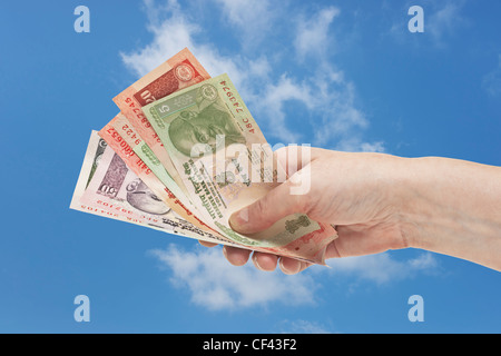Viele verschiedene indische Rupie Rechnungen mit dem Porträt von Mahatma Gandhi sind in der Hand gehalten. Himmel ist im Hintergrund. Stockfoto