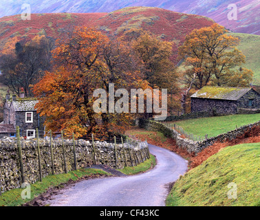 Blick entlang der kurvenreichen Landstraße in Richtung remote Cumbrian Dorf der Martindale im Lake District. Stockfoto