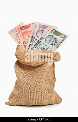 Viele verschiedene indische Rupie Rechnungen mit dem Porträt von Mahatma Gandhi sind in einem Jutesack. Stockfoto