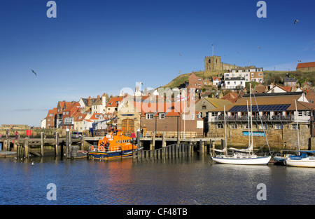 Whitby Rettungsboot vertäut außen Whitby Lifeboat Station unter St. Marys Kirche auf dem Hügel über. Stockfoto