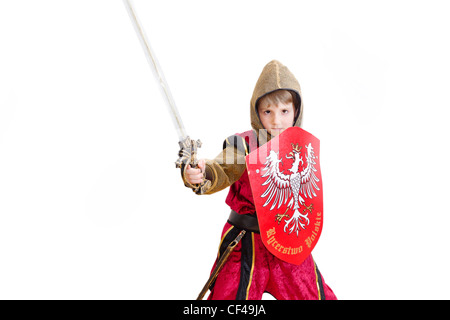 Junge mit Karnevalskostüm. Der kleine kämpfende Ritter mit polnischen Wappen auf dem Schild. Stockfoto