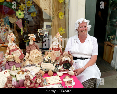 Ein Ladenbesitzer in einem viktorianischen Kostüm sitzen ihre waren bei den Dickens Festival 2010. Stockfoto