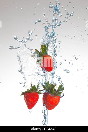 drei Erdbeeren mit Wasser bespritzt Stockfoto