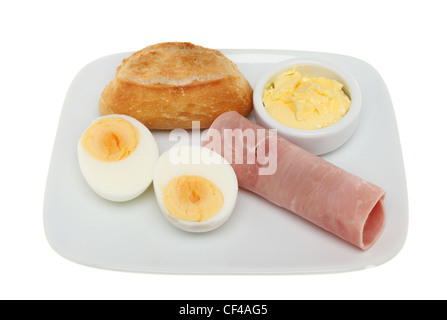 Petit Pain Brötchen, hart gekochtes Ei, Schinken und Butter auf einem Teller isoliert gegen weiß Stockfoto