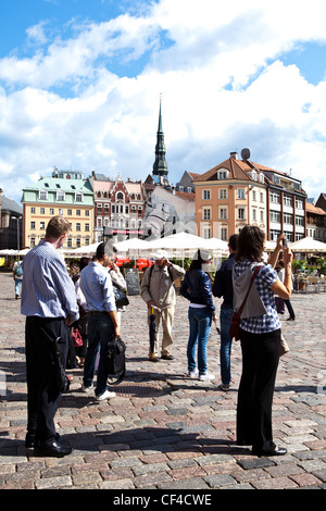 Menschen genießen den Blick auf eine Straßenszene in Riga. Stockfoto