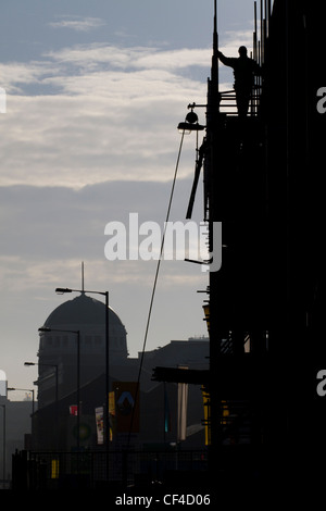 Thornton Road, Bradford, eine Silhouette Arbeiter auf Gerüsten mit Odeon im Hintergrund. Stockfoto