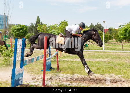 Jockey auf schwarzes Pferd springen in einer öffentlichen Sprung-Show. Stockfoto