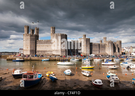 Caernarfon Castle und der Fluss-Seiont unter einem spektakulären dunklen Himmel. Stockfoto