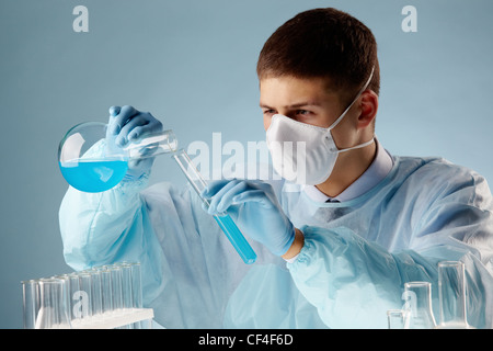Chemiker, bereit, eine Substanz in eine andere in Bezug auf Experiment zu gießen Stockfoto