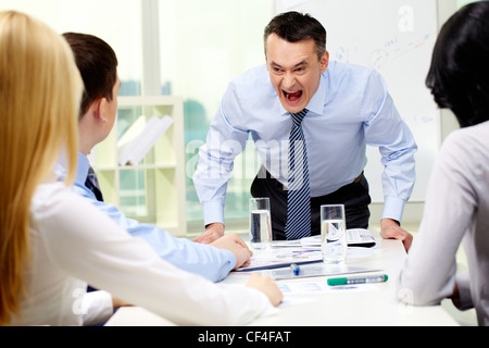 Wütend anzuschreien seine Arbeiter mit einem ausdrucksstarken Look Geschäftsmann Stockfoto