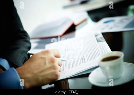 Bild der männlichen Hand mit Stift und Zeitung und Kaffee in der Nähe von Stockfoto