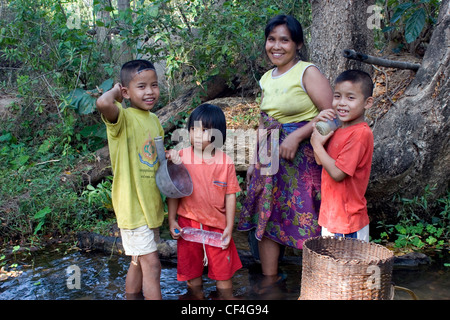 Frau Karen Flüchtlinge aus Burma (Myanmar) ist in einer Bucht mit ihren Kindern Ban Tha Ta Fang, Nordthailand Wäsche. Stockfoto