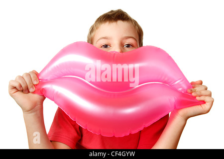 Junge hält Spielzeug, aufblasbare rosa Lippen. Isoliert auf weißem Hintergrund. Stockfoto