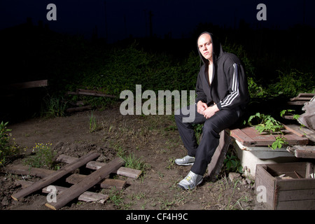 Gepumpte weißer Mann in Kapuzenjacke irgendwo in den slums Stockfoto