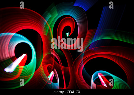 Abstrakte leuchtende Muster in Form von Spiralen auf schwarzem Hintergrund. Stockfoto