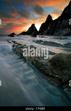 Die Flut Felsvorsprüngen an Westcombe überrollen, einem kleinen sandigen Bucht nur einen kurzen Spaziergang entlang der Süd/West Coast Path von Bi Stockfoto