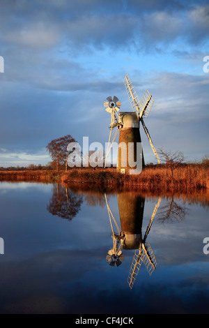 Ein Spiegelbild im Wasser des Turf Moor Wind Pumpe wie Hill auf den Norfolk Broads. Stockfoto