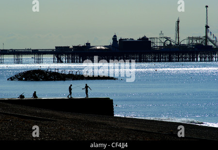 Angeln am Strand von Brighton mit dem Pier im Hintergrund. Stockfoto