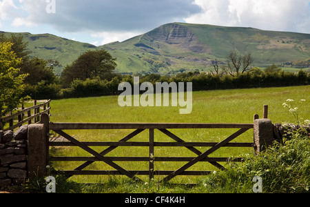 Blick über ein Feld über einen Hof in Richtung Mam Tor, einem Hügel in der hohen Peak Derbyshire, auch bekannt als das Zittern Mountai Stockfoto