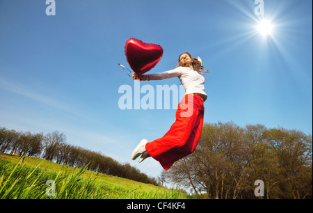 Fröhliches springen Mädchen auf Grünland Stockfoto