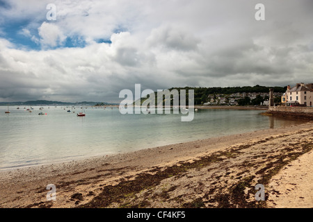 Der Strand in der kleinen Ortschaft Beaumaris über die Menaistraße in Anglesey. Stockfoto