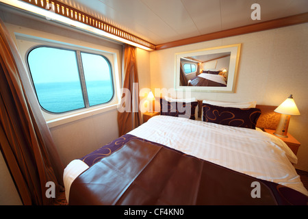 Kabine mit Doppelbett und Fenster mit Blick auf Meer Sommertag zu versenden. Stockfoto