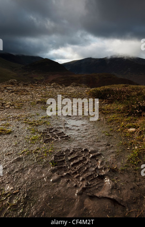 Ein Schuh im Schlamm mit Blick auf den Cumbrian Hügeln hinter print. Stockfoto