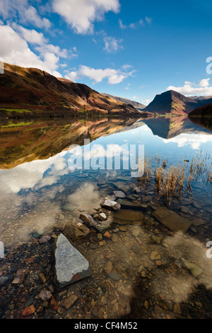 Die umliegenden Berge spiegeln sich in den ruhigen Gewässern des Buttermere-See. Stockfoto