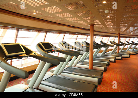 große Sporthalle mit Laufbändern in der Nähe von Fenstern in Kreuzfahrt Schiff Gesamtansicht Stockfoto